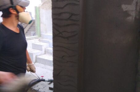 Application of shotcrete mixture on the wall with subsequent carving of patterns